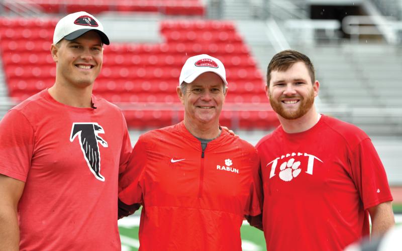 Wade Cheek/The Clayton Tribune. Charlie Woerner (left) and Bailey Fisher (right) stand for a photo with Rabun head football coach Rance Gillespie, capping off the Wildcats’ youth football camp on Saturday, May 10.