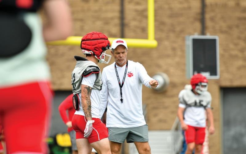 Wade Cheek/The Clayton Tribune.  Rabun County head football coach Rance Gillespie coaches up rising senior linebacker/running back Noah English during the Wildcats’ May 13 practice.