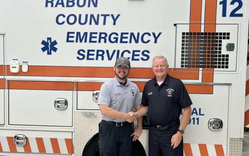Photo courtesy Rabun County EMS. Will Shanks (left) is Rabun County Emergency Services’ newest Nationally Registered Paramedic. Rabun County EMS/911 Director Mike Carnes congratulates Shanks and shakes his hand.
