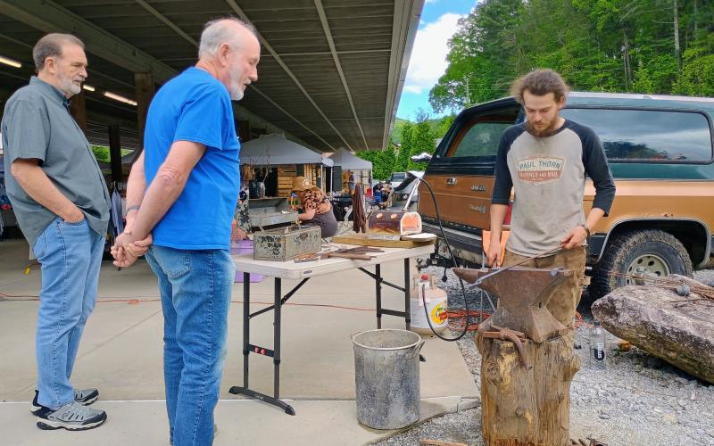Megan Horn/The Clayton Tribune. Eli Bundrick demonstrates blacksmithing for event-goers Ron Mooney and Clyde Cook at Dinglerfest 2025.