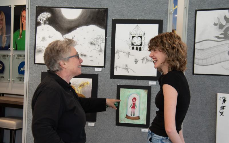 Submitted photo. :TFS sophomore Olivia Bonner shows middle school counselor Elizabeth Kyle a piece of her artwork at the Evening of the Arts.