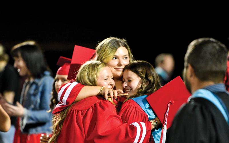 Wade Cheek/The Clayton Tribune. Rabun County Class of 2025 graduates Madi Griffin, Haylee Queen and Mattie Wofford hug at the conclusion of the Wildcats’ commencement ceremony on May 23 at Frank Snyder Memorial Stadium.