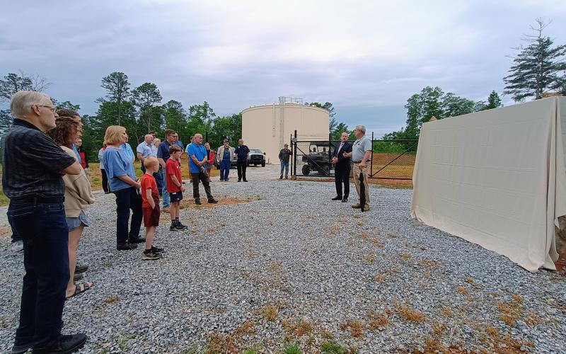 Megan Horn/The Clayton Tribune. Rabun County Water and Sewer Authority (RCWSA) Chairman Sam Beck and Rabun County Commissioner Kent Woerner (pictured right) give remarks prior to the unveiling during a dedication ceremony with community members and family members of the late Greg Peters on May 19.
