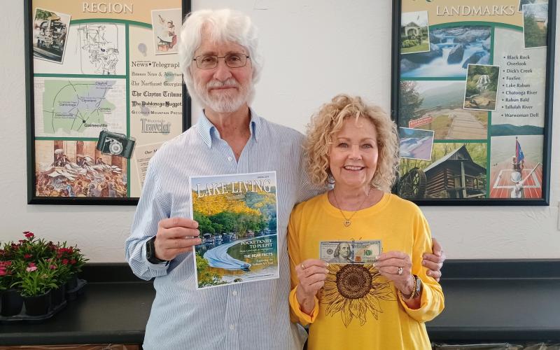 Megan Horn/The Clayton Tribune. Spring 2025 “Lake Living” cover winner Morgan Harvill (left) is pictured with his wife, Judy. The magazine cover features a MasterCraft boat on Lake Rabun in Rabun County at the narrows around September 2024. In addition to gracing the cover of Spring 2025 “Lake Living,” Harvill received $100.