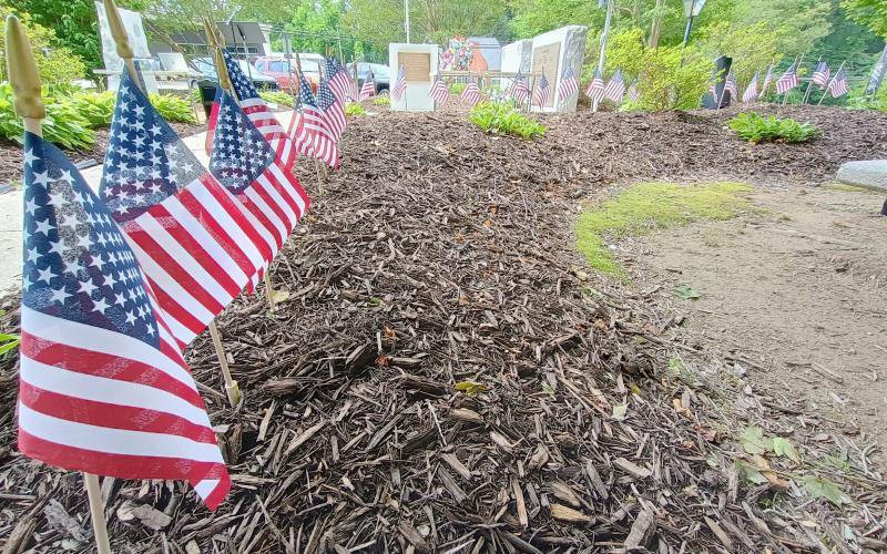 Megan Horn/The Clayton Tribune. Community members placed 48 flags at the memorial for “all who served honorably” and passed away this past year during the Monday, May 26, Memorial Day Ceremony.