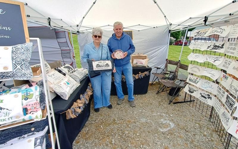 Megan Horn/The Clayton Tribune. Tom and Lisa Hudgins of Franklin, N.C. feature decorative and inspired pillows from Threaded Creations during last Saturday’s Of These Mountains Spring MarketPlace.
