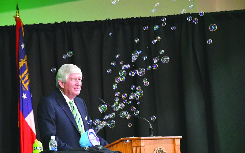 Enoch Autry/The Clayton Tribune. Graduation speaker Dink NeSmith, co-owner of Community Newspapers, Inc., utilizes a soap bubble machine during his speech, noting how bubbles are like dreams. NeSmith told the Tallulah Falls School graduates to remember a “no” can be a stumbling block or it can be a stepping-stone in their path to making their dreams come true.