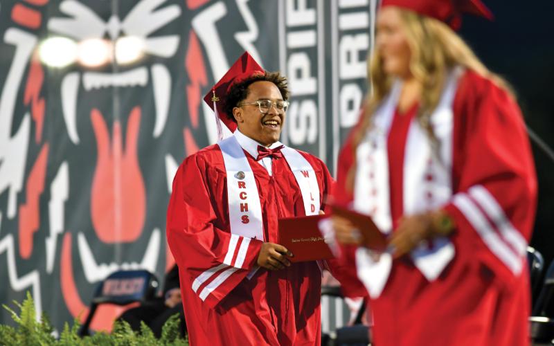 Wade Cheek/The Clayton Tribune. Senior football player and soon Reinhardt University football player Ta’Quavian Hargrove walks off the RCHS grad stage with a smile. He is known for his happy demeanor across the entire school community.