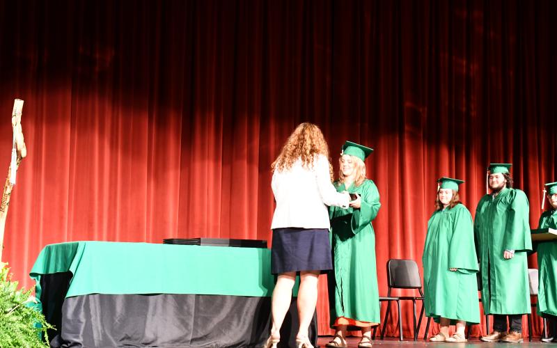 Megan Horn/The Clayton Tribune. Mountain Education Rabun Campus Principal Christine Bray (left), hands 2025 graduate Brooke Caroleen Richardson her diploma during the May 28 graduation ceremony.