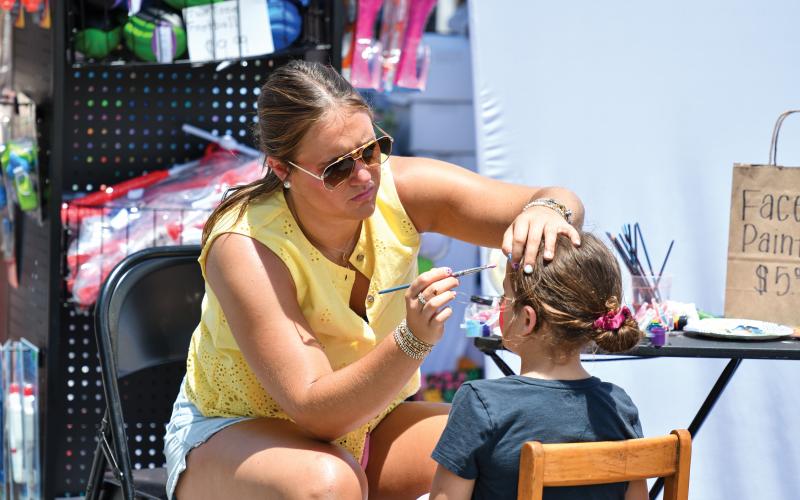 Wade Cheek/The Clayton Tribune. Ellie Southards (left) spent last Saturday’s Ramshackle event working on face paints for kids attending the event that saw thousands fill Main Street.