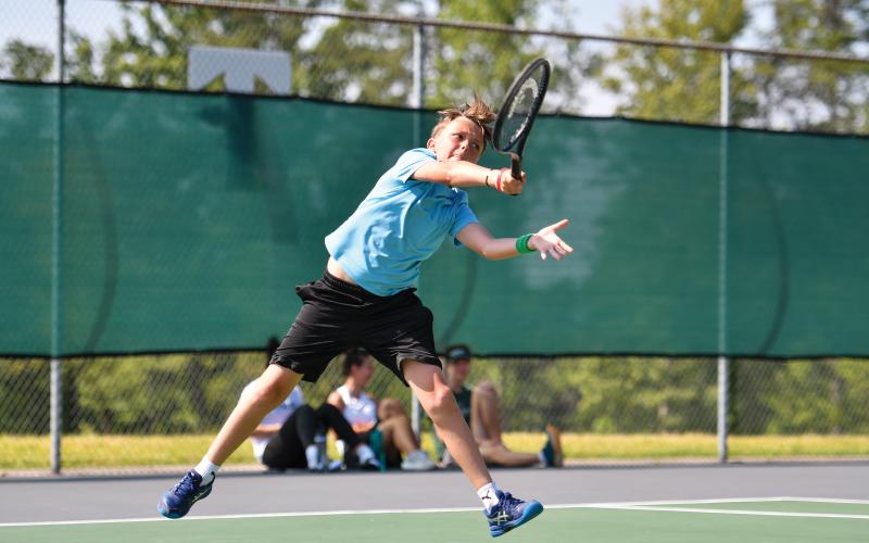 Wade Cheek/The Clayton Tribune. Turner Lander leaves his feat to fire a serve to his opponent.