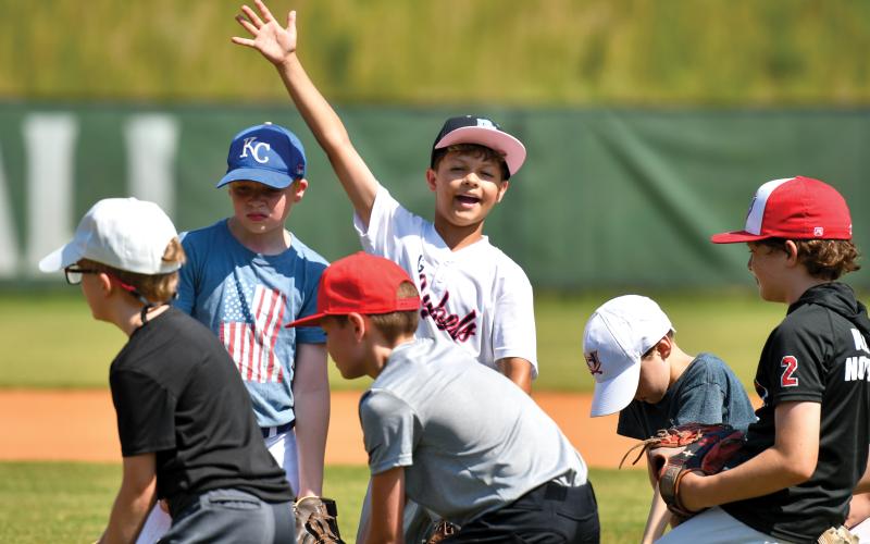 Wade Cheek/The Clayton Tribune. Aiden Terrell waves to the camera during the TFS kids baseball camp on Wednesday, June 11.