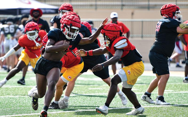 Wade Cheek/The Clayton Tribune. Junior running back/linebacker Jakaden Shiflet breaks the tackle of a Clarke Central defender at Buford High School’s padded camp on Wednesday, June 18.