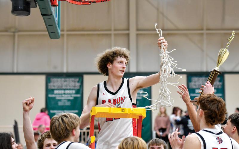 Wade Cheek/The Clayton Tribune. Rabun County post Hayes Free hoists up the net after the Wildcats won the 8A-DI region title over Commerce High School last season.