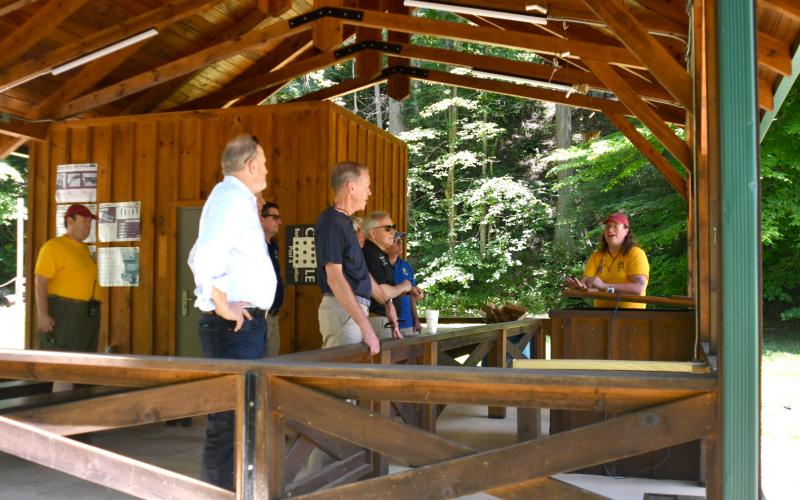 Enoch Autry/The Clayton Tribune. Scout Eden Griffin (far right) explains the rifle range facility at Camp Rainey Mountain.