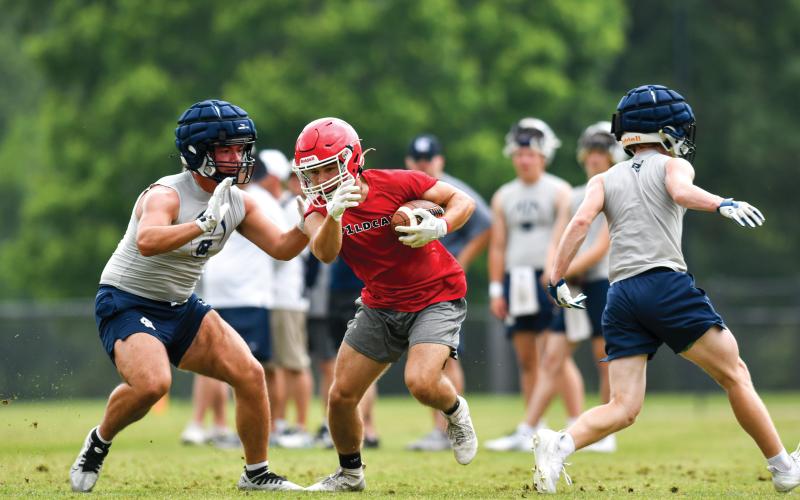 Wade Cheek/The Clayton Tribune. Wildcat senior wide receiver Evan Page weaves through White County defenders during a 7-on-7 matchup between Rabun County and the Warriors at Athens Academy on  June 4.