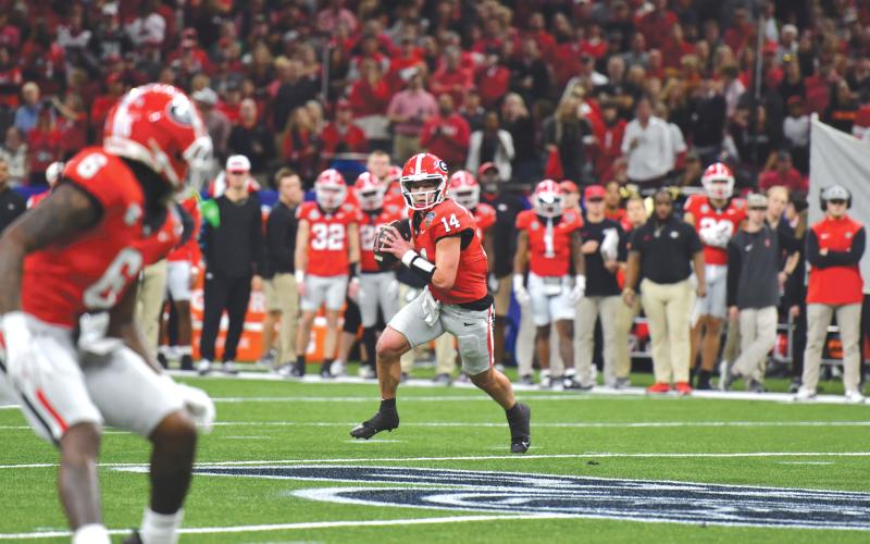 Wade Cheek/The Clayton Tribune. Georgia quarterback Gunner Stockton scrambles to complete a pass to wide receiver Dominic Lovett in January’s Sugar Bowl loss to Notre Dame. Stockton, tops on the UGA depth chart heading into the 2025 football season, was a state record-setting quarterback for Rabun County.