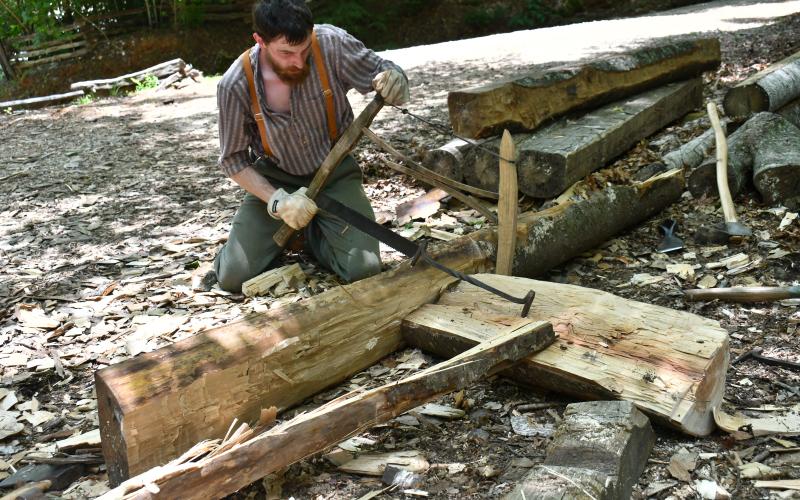 Megan Horn/The Clayton Tribune. Christopher Botkin demonstrates his craft as he works to saw a log during Foxfire Heritage Days last weekend. The two-day fundraiser event on June 6 and 7 celebrated folklife traditions and supported local nonprofit Foxfire.