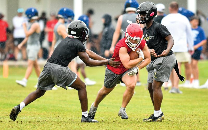 Wade Cheek/The Clayton Tribune. Rabun County senior running back Lake Evans runs through two Greene County defenders en route to a short gain. Evans split reps with fellow running backs Reid Giles and Noah English at Athens Academy last week.