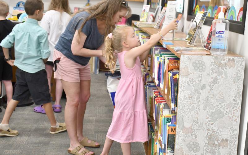 Megan Horn/The Clayton Tribune. Olive, 5, and Deidra Watts participate in the launch of the Summer Reading Program “Color Our World” at the Rabun County Public Library Tuesday, June 3. The pair browse the shelves in the children’s room.