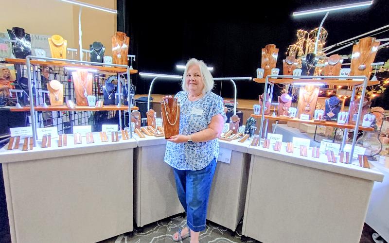 Megan Horn/The Clayton Tribune. Anne Autsolief, owner of “Designs by Anne,” exhibits her handcrafted chainmaille and metal jewelry last weekend at the Painted Fern Art Festival presented by the North Georgia Arts Guild. Autsolief said she has been making jewelry for 18 years.