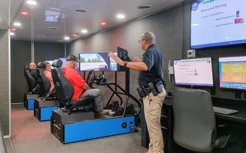Megan Horn/The Clayton Tribune. Officer Hammock with the Georgia Department of Public Safety Motor Carrier Compliance Division instructs Transportation Department employees on driver education safety with a driving simulator. Rabun County Schools held its back to school meeting on July 29 at the Rabun County Board of Education.