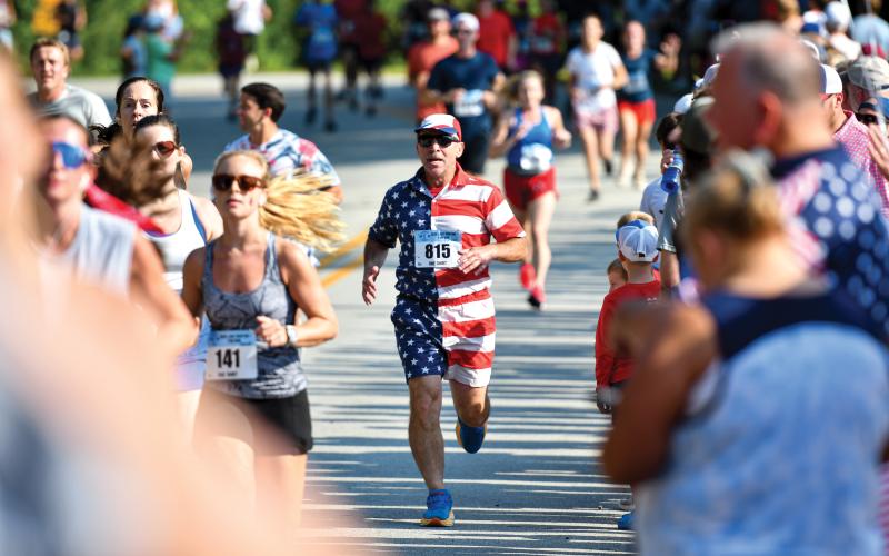Wade Cheek/The Clayton Tribune. Axel Fiksman of Atlanta (815) was one of the many runners at the Lake Burton Fun Run to dress from head to toe in red, white and blue in celebration of Independence Day last weekend.