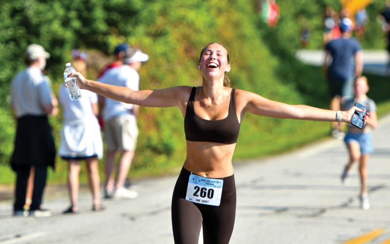 Wade Cheek/The Clayton Tribune. Waynesville, N.C., resident Abigail Voehl extends her arms in relief as she completes this year’s Lake Burton Fun Run on Saturday, July 5.