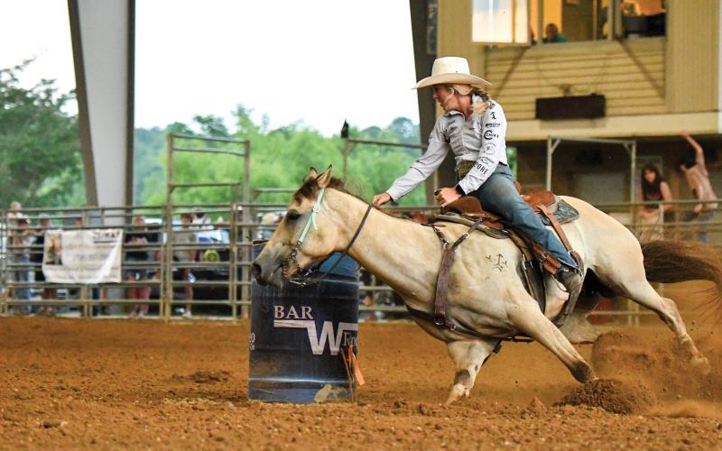 Wade Cheek/The Clayton Tribune. Kristin Yde makes the tight turn around a barrel at the rodeo on July 5