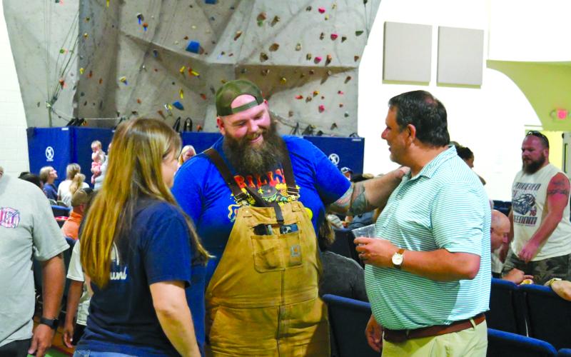 Enoch Autry/The Clayton Tribune.  Kyle Bryner, winner of this season’s “BBQ Brawl” talks with Todd Faircloth, executive director of the Foxfire Museum, at the July 27 watch party for the Food Network broadcast.