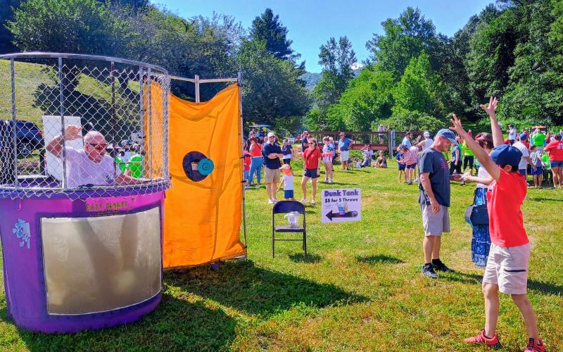 Megan Horn/The Clayton Tribune. Joseph Gabinsky, 11, celebrates after dunking Paul Beasley in the Dunk Tank. The tank was one of many fun activities for kids in the Kids’ Zone during Sky Valley’s Independence Day festivities on July 5.