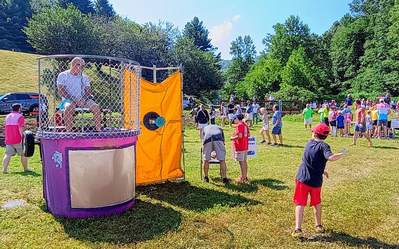 Megan Horn/The Clayton Tribune. Nolan Gardener, 9, throws shots at the Dunk Tank in Sky Valley on Saturday, July 5, during Independence Day activities in the Kids’ Zone. He eventually dunks Paul Beasley and celebrates.