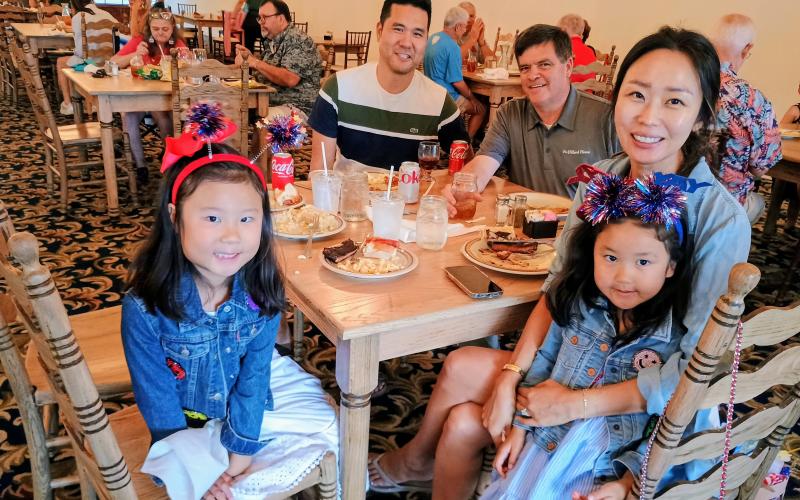 Megan Horn/The Clayton Tribune.  It was family fun at The Dillard House on July 4 for annual Independence Day celebrations. The Dillard House has been celebrating the tradition for decades. Pictured enjoying their buffet meal are Emmy Lim, 6; David Lim; John Dillard, Legacy Ventures and Manager of The Dillard House; Stella Lim; and Colette Lim, 4, dressed in patriotic attire as they enjoy the festivities.