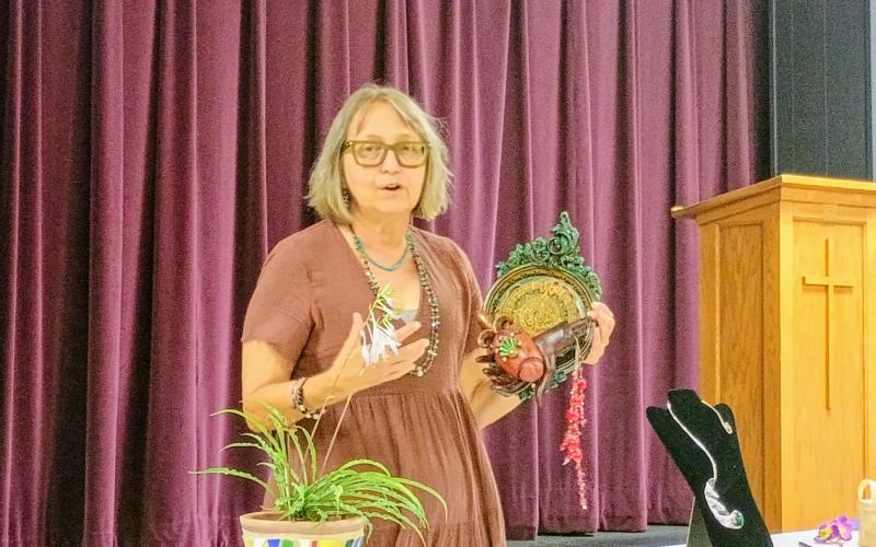 Megan Horn/The Clayton Tribune. Helen Rogers displays her art as part of a series called “Ministries of the Heart” during the July 17 “Members’ Show and Tell” Program.  She said some of her inspiration came from embracing the aesthetic she sees in Catholic churches.