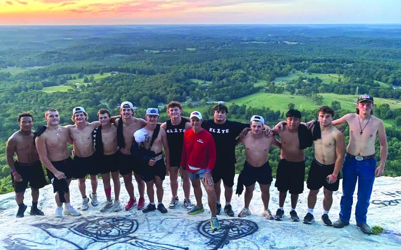 Submitted photo. Rabun County football players stand with head coach Rance Gillespie (center) on Currahee Mountain.