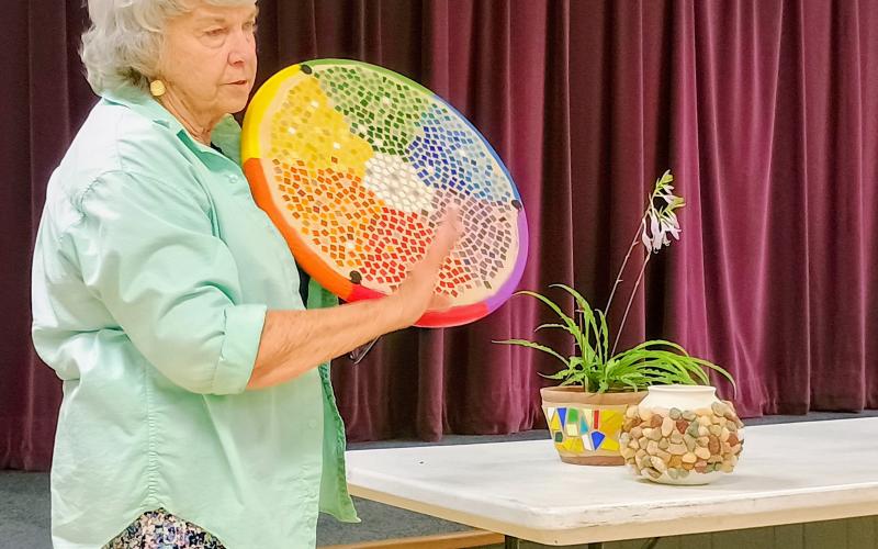 Megan Horn/The Clayton Tribune. North Georgia Arts Guild member Kathy Ford shows colorful artists pieces she has been working on involving tiles and pottery during the July 17 “Members’ Show and Tell” program. Particularly, her color wheel table with painted edges captured the eyes of everyone at the meeting.