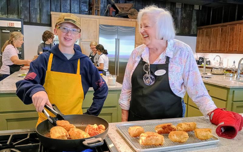 Megan Horn/The Clayton Tribune. Chris Woodall and Kitchenettes Volunteer Nancy Parrott have a great time cooking at the Teaching Kitchen as they help prepare for a four-course meal served on July 25.