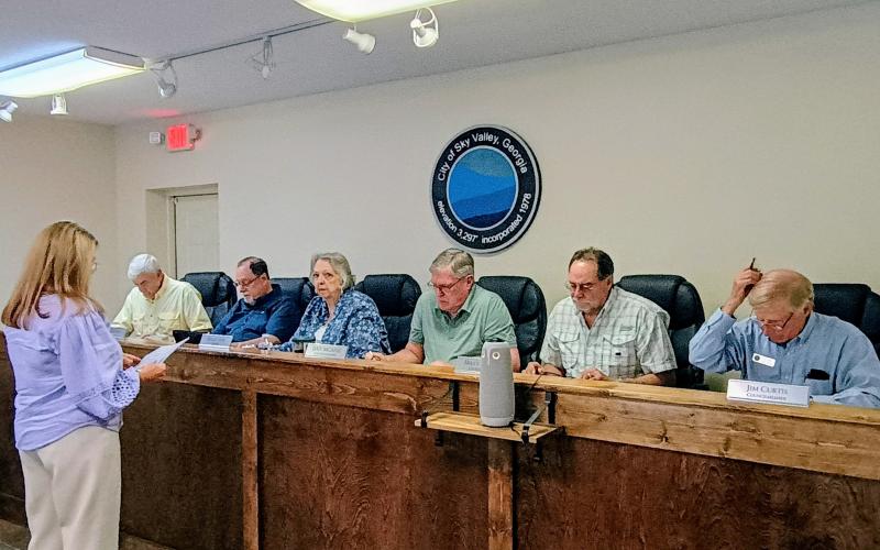 Megan Horn/The Clayton Tribune. Joely Mixon with Mixon, Mixon, Brown &amp; Tench, CPAs, left, gives a presentation of the Fiscal Year (FY) 2024 audit to Sky Valley council members Tony Allred; Bill Oliver; Mayor Hollie Steil; Dan McAfee; Bruce Turner and Jim Curtis during the July 15 city work session.