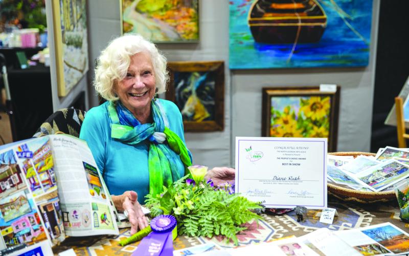Photo courtesy Mark Barton. Diane Rush was the winner of this year’s “People’s Choice Award for Best in Show” after attendees at the Painted Fern Art Festival cast their ballots Saturday, July 12, and Sunday, July 13. Rush exhibited her colorful paintings, many of which capture historic landmarks in and around Clayton. Several of her paintings also showcase the beautiful wildlife and nature in the Northeast Georgia area.