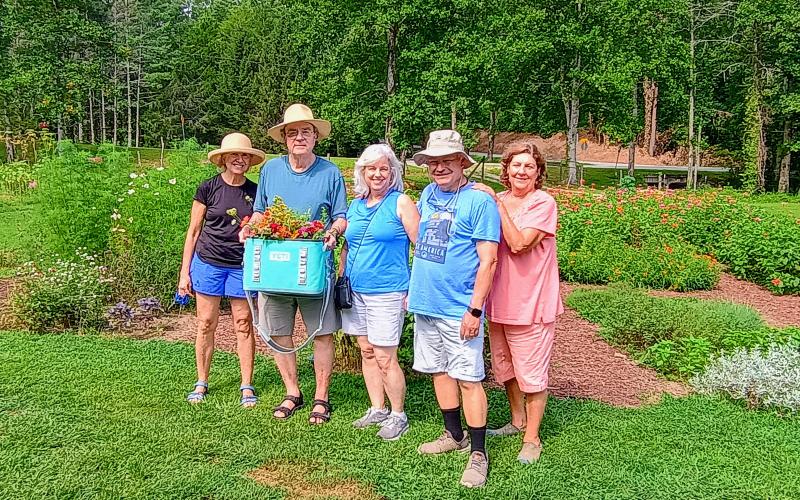 Megan Horn/The Clayton Tribune. Cindy Wright, left; Robert Waller; Serrell Stoke; John Stoke and Collin Lines showcase the colorful Zinnia arrangements they cut and created themselves at Zinnia Happiness Farms.