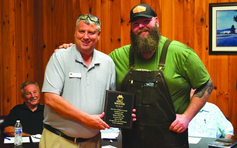 Enoch Autry/The Clayton Tribune. Dillard Mayor Claude Dillard presents Kyle Bryner with a plaque from the City of Dillard for the owner of Blue Hound’s reality cooking show win on the Food Network’s “BBQ Brawl” for season six.