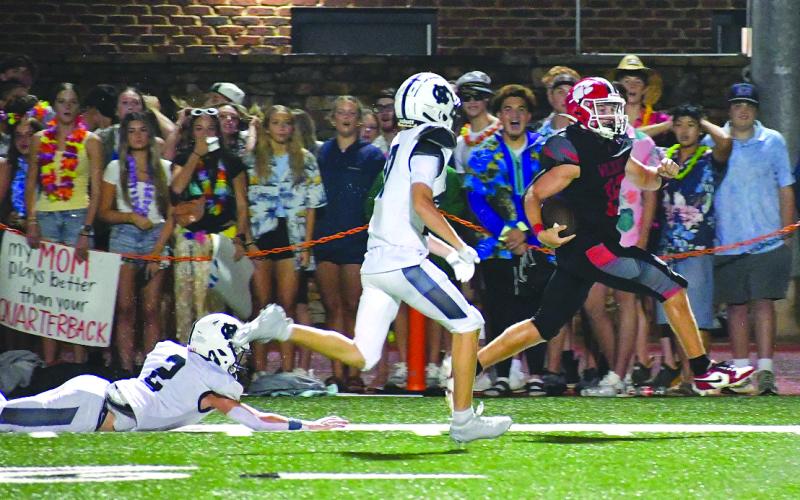 Enoch Autry/The Clayton Tribune. Rabun County senior running back Reid Giles sprints down the sideline in front of a group of RCHS students on Aug. 15 for a 65-yard touchdown against visiting White County in the Wildcats’ 42-6 win on “Hall of Fame Night.” Giles, a preseason all-state selection, scored three TDs.