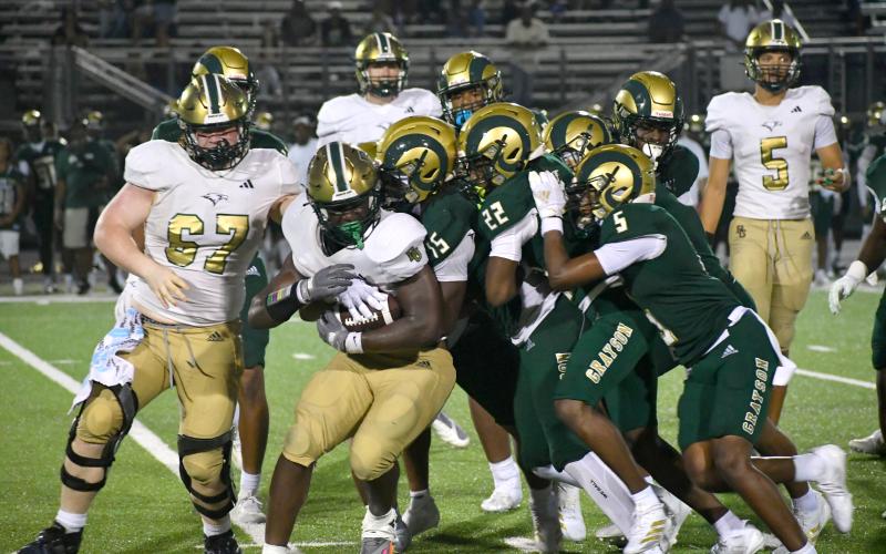Wesley Branch/The Clayton Tribune. Sophomore running back Royce Djouguem fights off Grayson defenders in Rabun Gap’s opening game on Aug. 22.