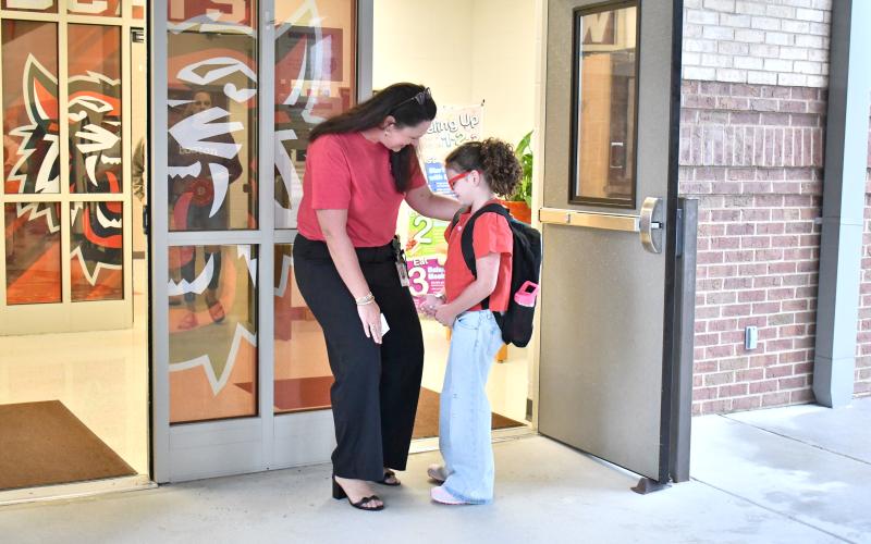 Megan Horn/The Clayton Tribune. Rabun County Primary School Principal Carla Truelove welcomes  Shiloh Welborn, 8, on her first day of second grade Monday, Aug. 4.