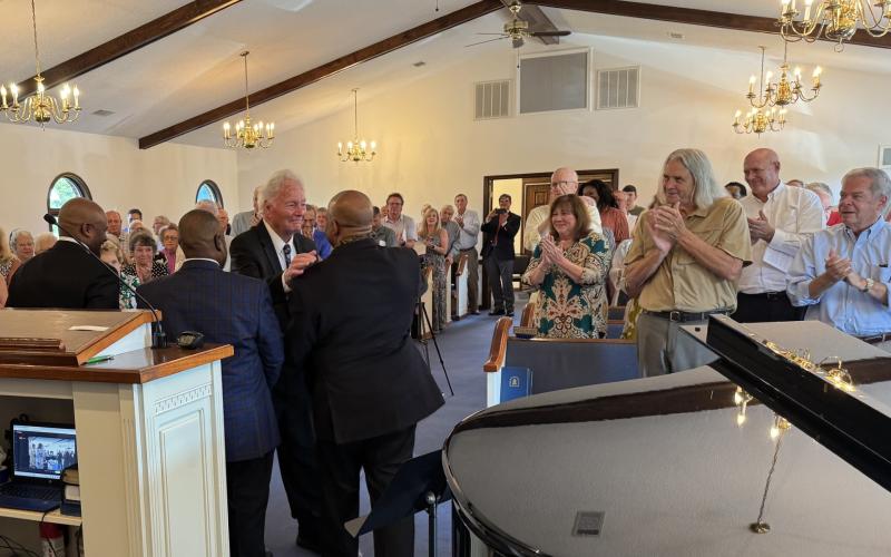 Submitted. letcher Wolfe of Sky Valley greets former members of the Atlanta Boy Choir at Rabun Gap Presbyterian Church at a Sunday concert. Wolfe founded and directed the choir for 60 years.