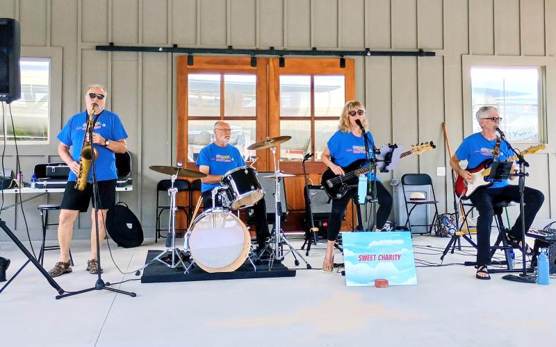 Megan Horn/The Clayton Tribune. Sweet Charity’s Playing It Forward provided musical entertainment during the Saturday, Aug. 16, “Touch-A-Truck” event. The band plays at numerous events to support important causes. During last weekend’s event, band members encouraged participants to donate and support the nonprofit Rabun County Fuller Center for Housing. Pictured are George Vorees on saxophone; Bill Lisenby on the drums; Karen Bacon on bass and David Bacon on guitar.