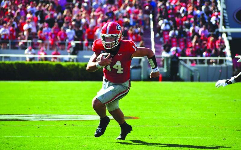 Wesley Branch/The Clayton Tribune. Georgia quarterback Gunner Stockton runs for extra yards for the Bulldogs. Stockton will have his Rabun County jersey retired on Friday, Sept. 19.