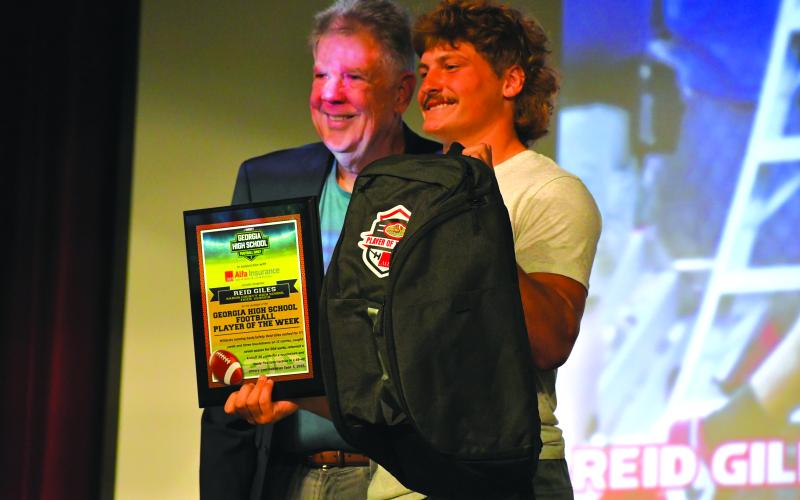Wesley Branch/The Clayton Tribune. Rabun County senior Reid Giles and Georgia High School Football Daily marketing director Ted Langford pose together after Giles receives his “Player of the Week” plaque on Sept. 10 at Rabun County High School.