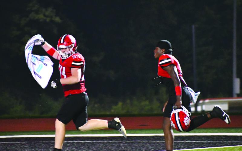 Enoch Autry/The Clayton Tribune. Ryan Yearwood and JK Fruster celebrate the Wildcats’ win over Fannin County on Aug. 22 as they run to ring the bell.