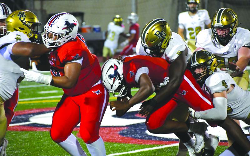 Wesley Branch/The Clayton Tribune. Providence Day quarterback Zaid Lott is tackled by a pair of Rabun Gap defenders. The Eagles sacked Lott multiple times in the 55-34 loss on Sept. 19 versus the Chargers.